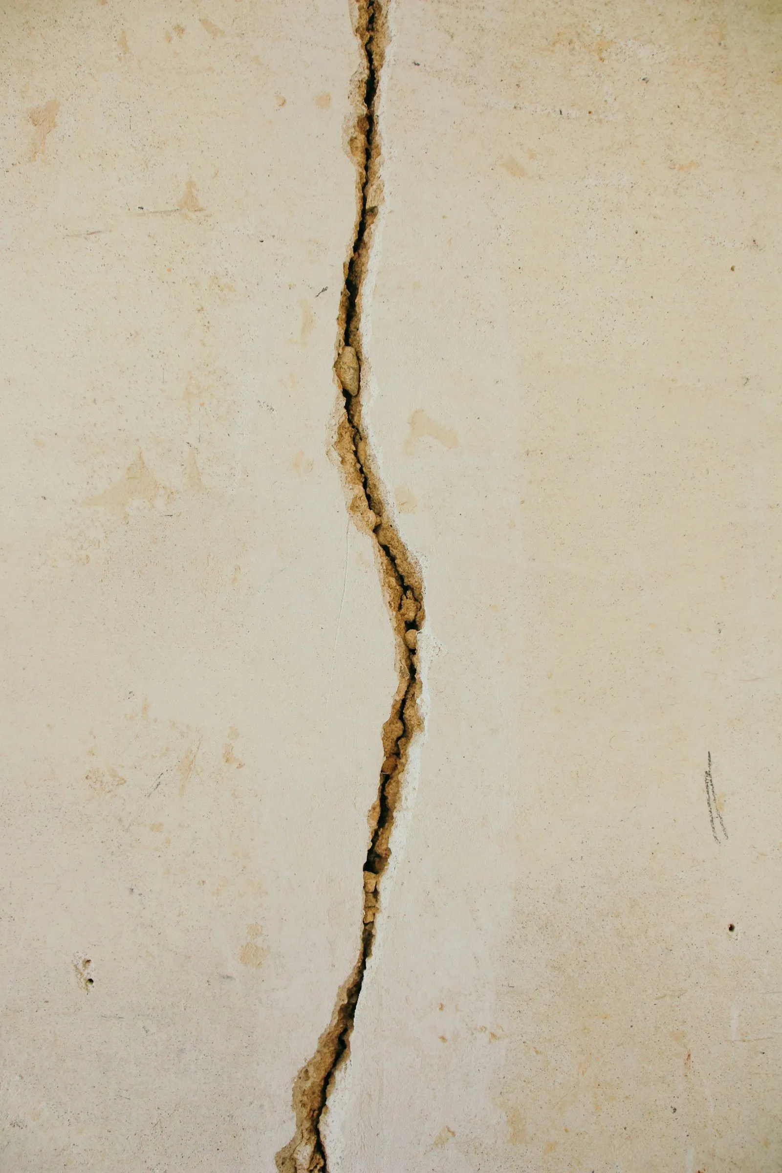 Vertical hairline crack in concrete foundation wall
