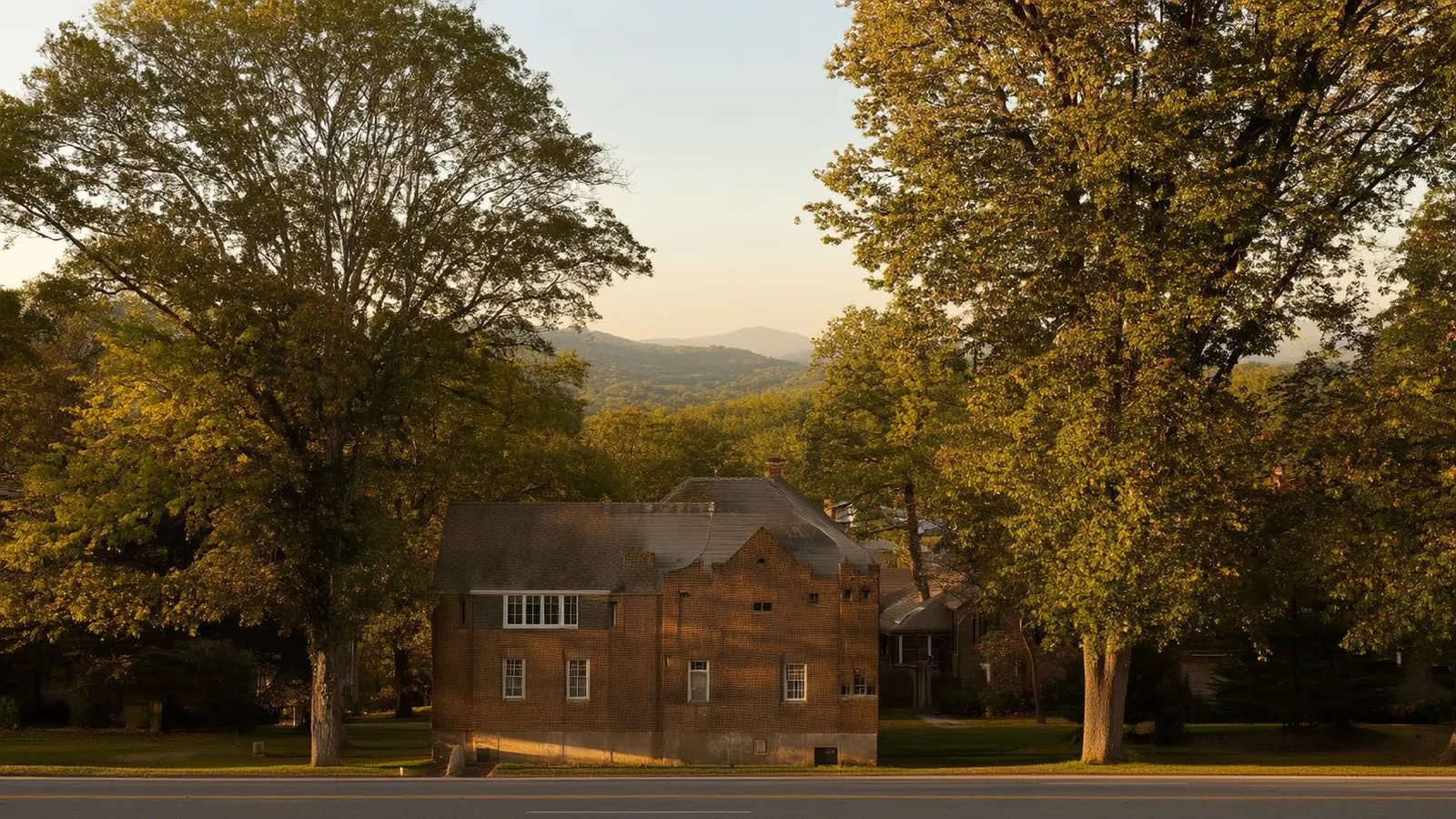 Brick home in Chattanooga framed by mature trees, with the Tennessee Valley Ridge-and-Valley terrain in the background